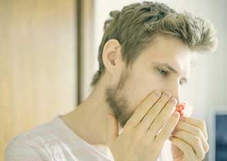 young man pinching nose bleed